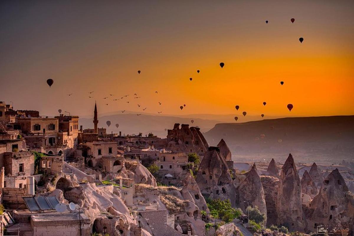 eine Gruppe von Heißluftballons, die bei Sonnenuntergang in den Himmel fliegen