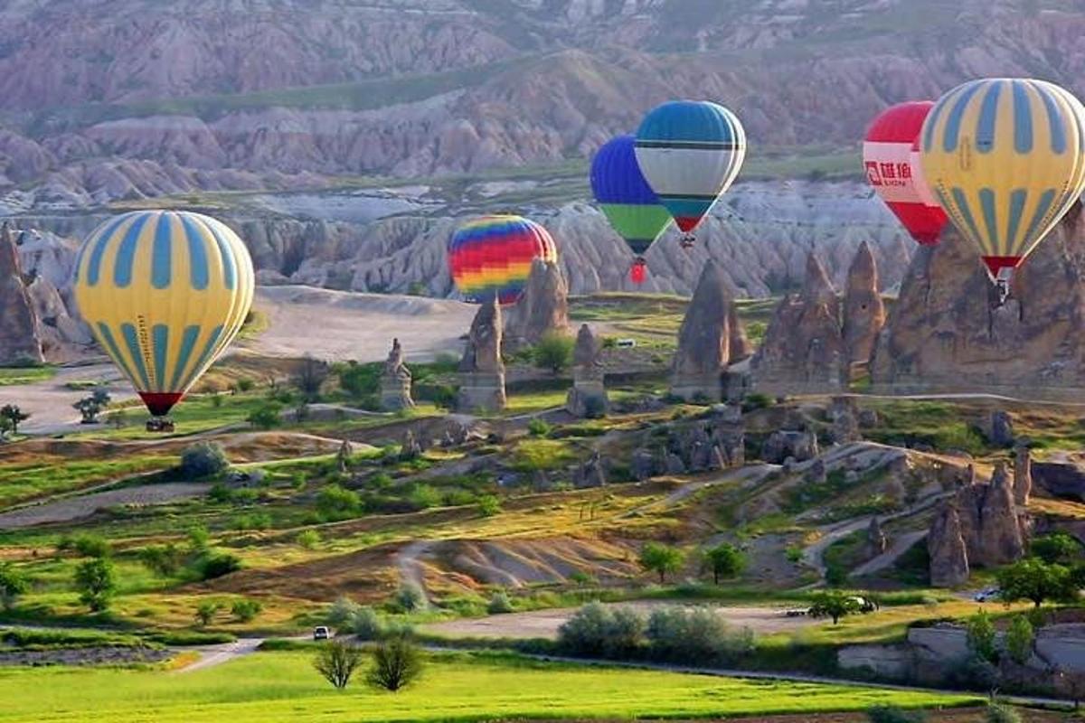 un gruppo di mongolfiere che sorvolano una formazione rocciosa