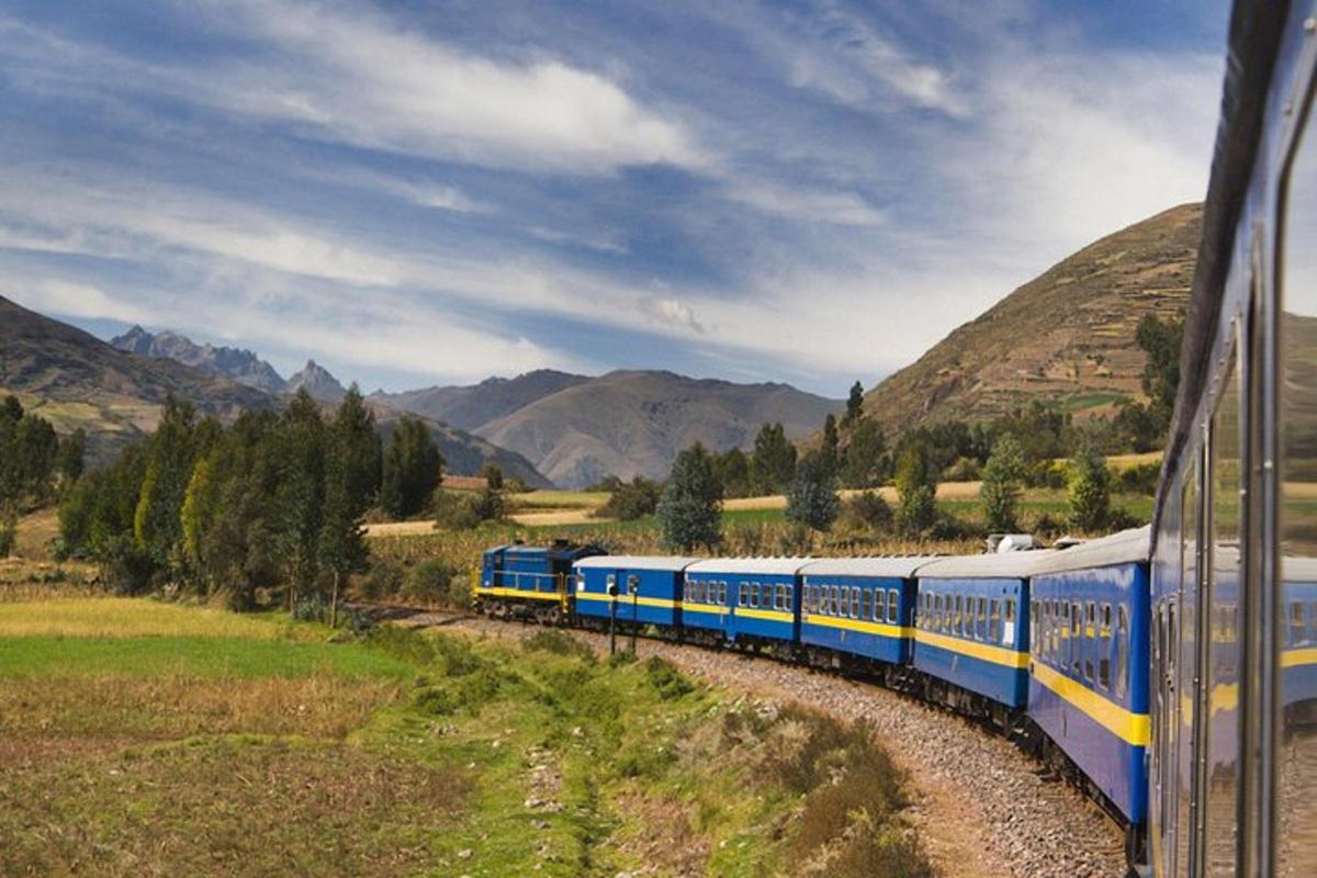 kereta api biru dan kuning yang bergerak melalui pergunungan