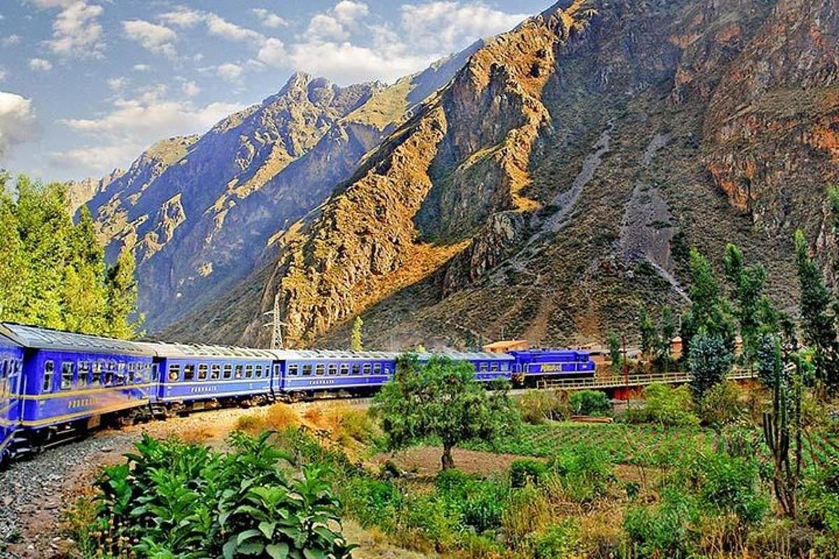 sebuah kereta api biru bergerak melalui banjaran gunung