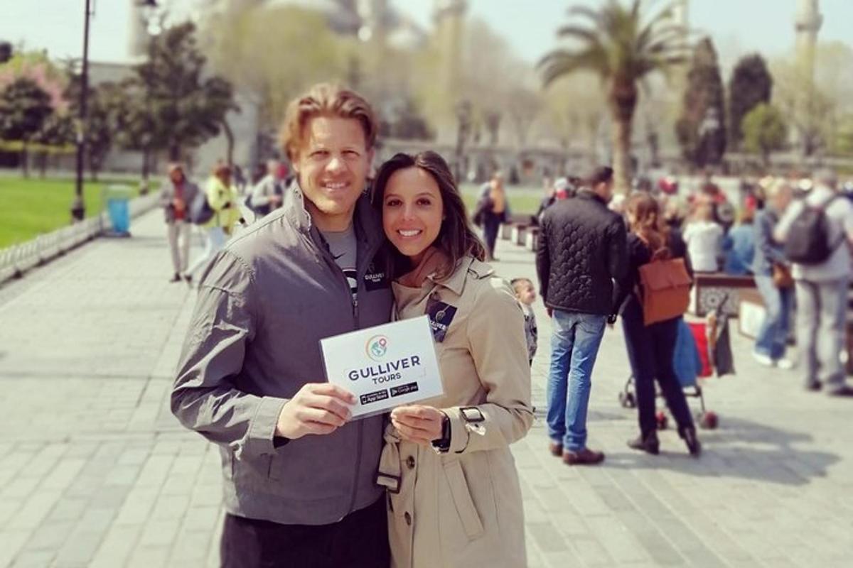 a man and woman holding a sign in a park