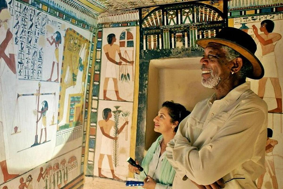 um homem usando um chapéu em pé em frente a uma pintura