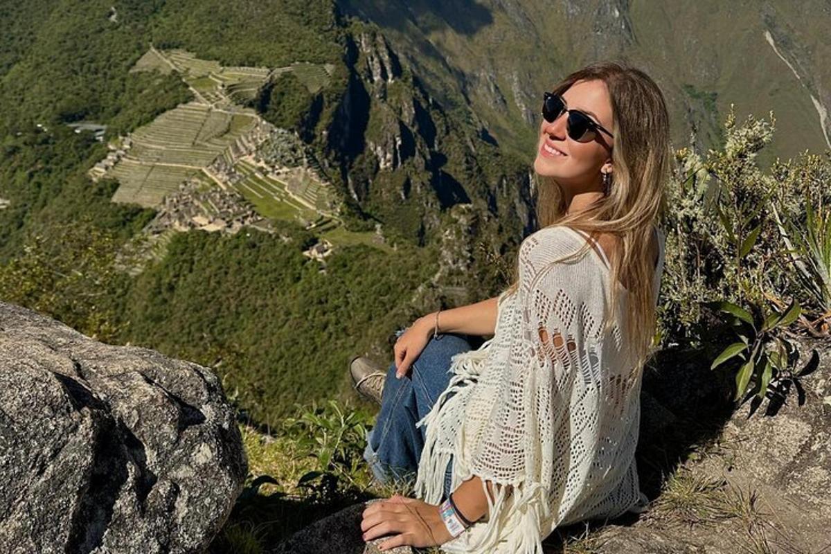 μια γυναίκα που κάθεται στην κορυφή ενός βουνού