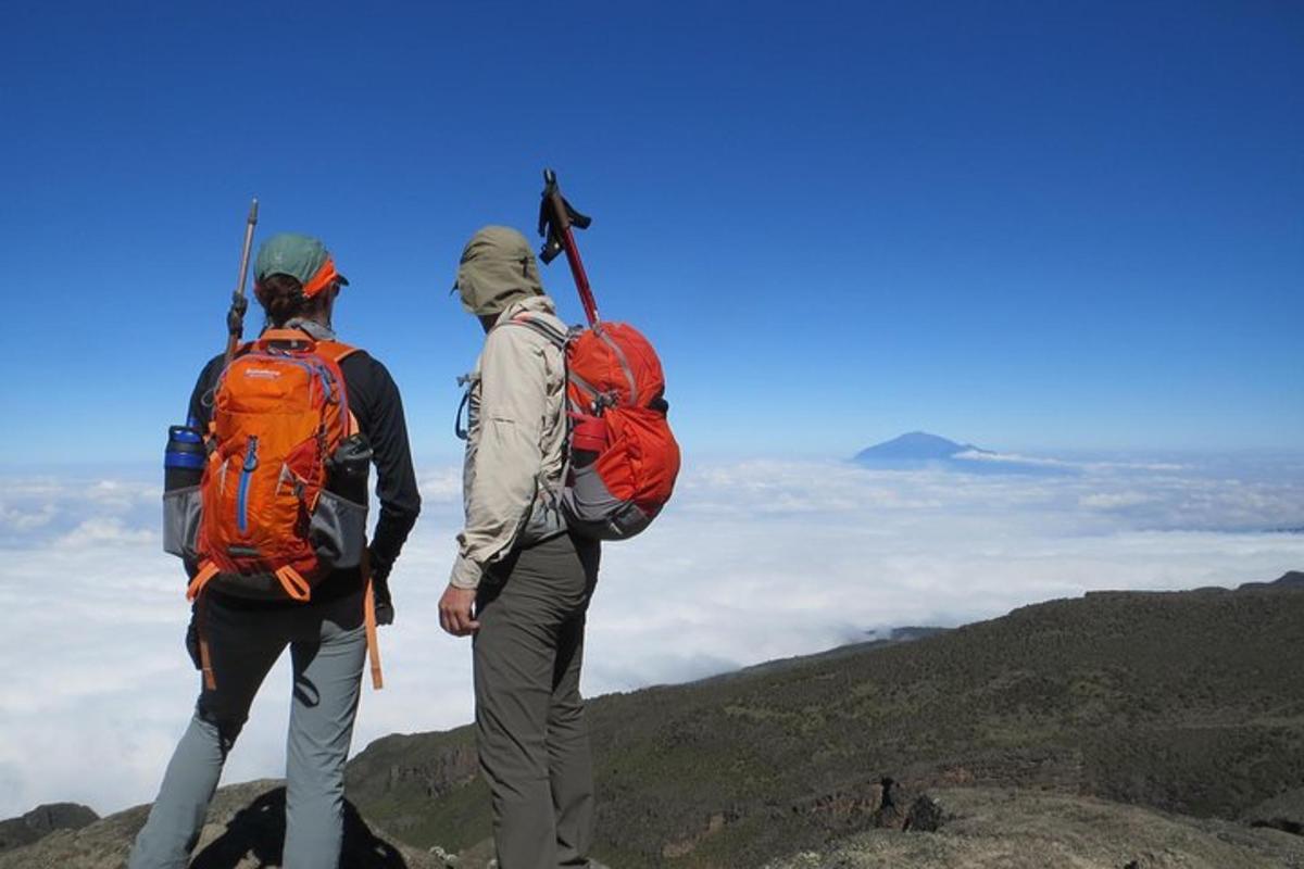 due persone con zaini in piedi sulla cima di una montagna