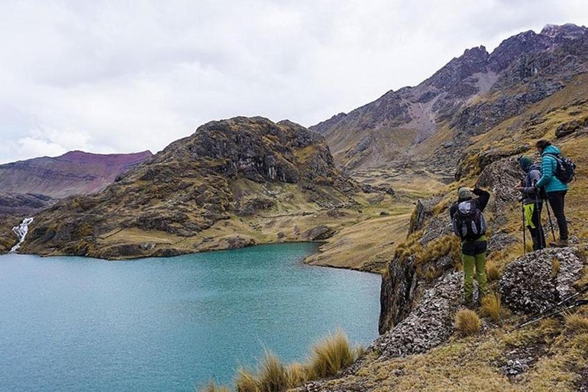 due persone in piedi su una montagna che domina un lago