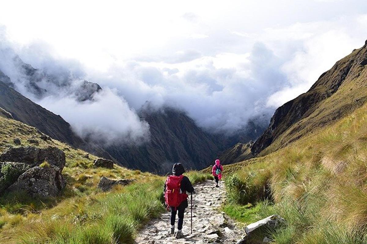 dua orang berjalan menyusuri jalan setapak di gunung