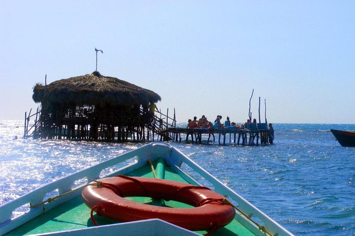 um barco com uma jangada na água com um píer