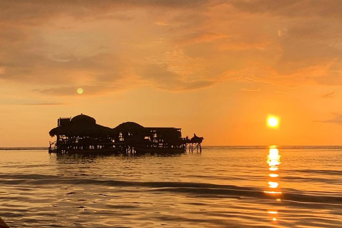isang pier sa karagatan na lumulubog ang araw