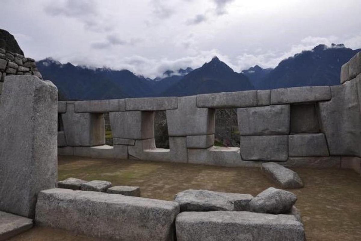 uma representação de um edifício de pedra com montanhas ao fundo