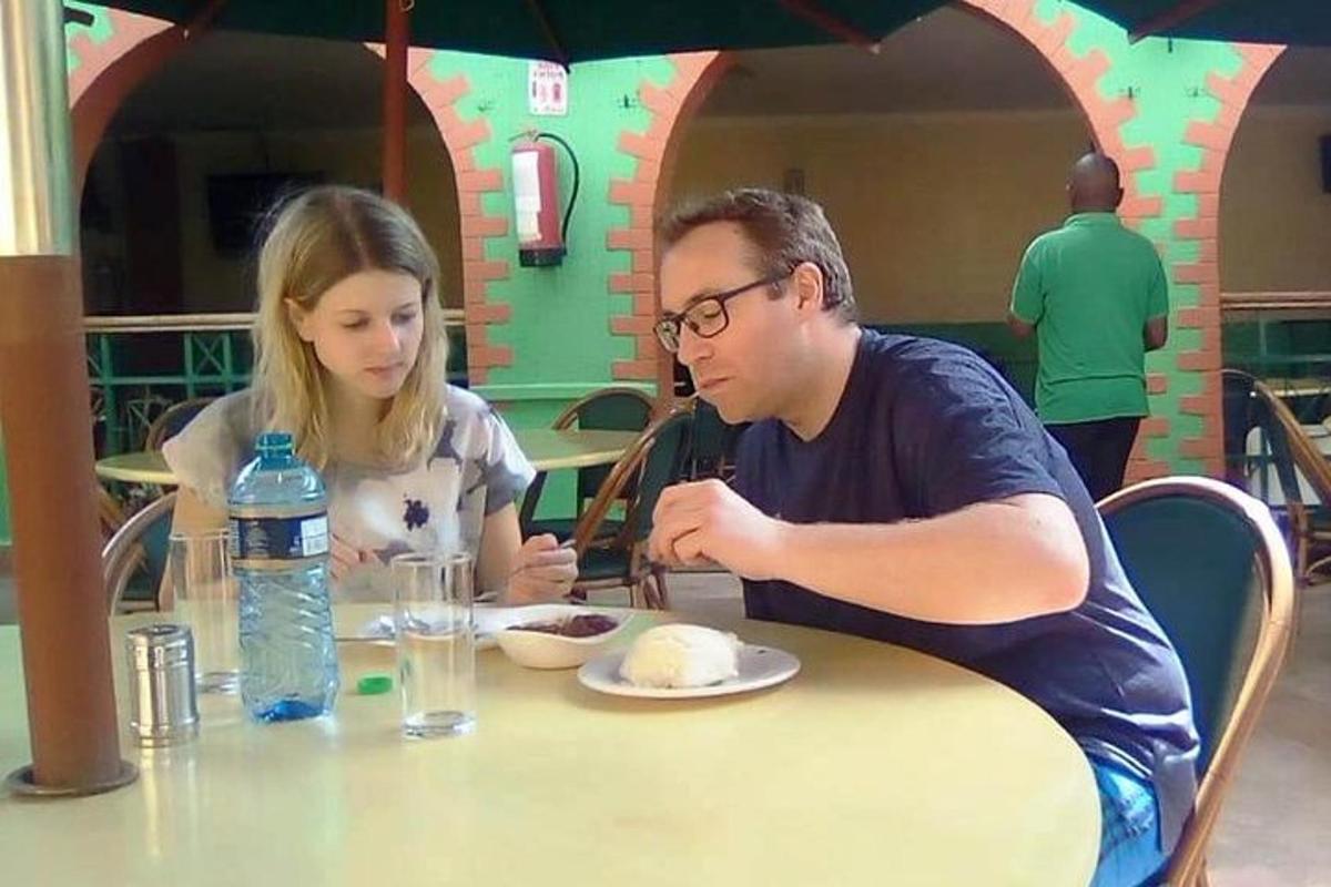 un uomo e una donna seduti a un tavolo che mangiano cibo