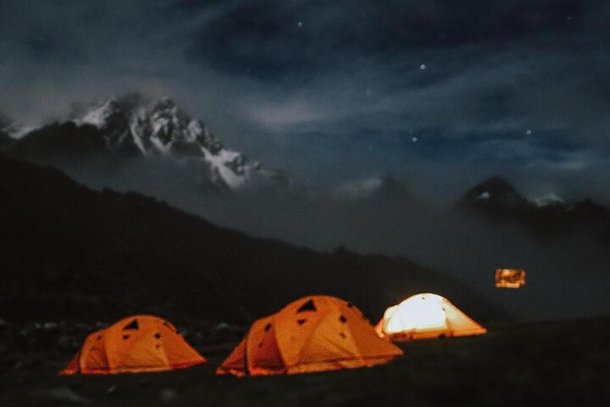 tre tende in un campo di notte con una montagna