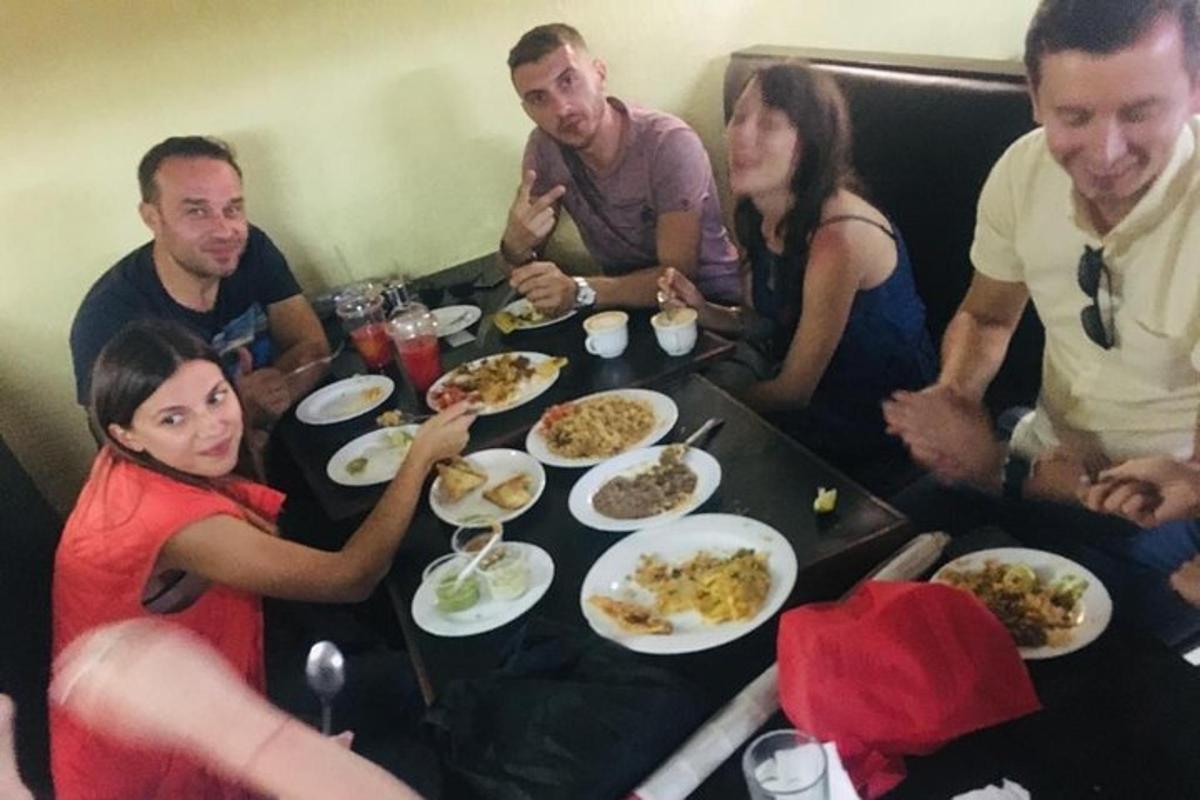 un gruppo di persone sedute attorno a un tavolo che mangiano cibo