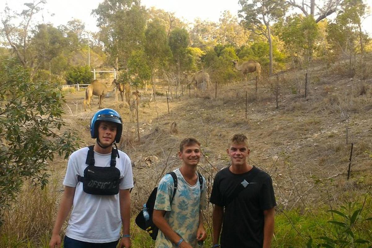 三个男人站在一群大象前