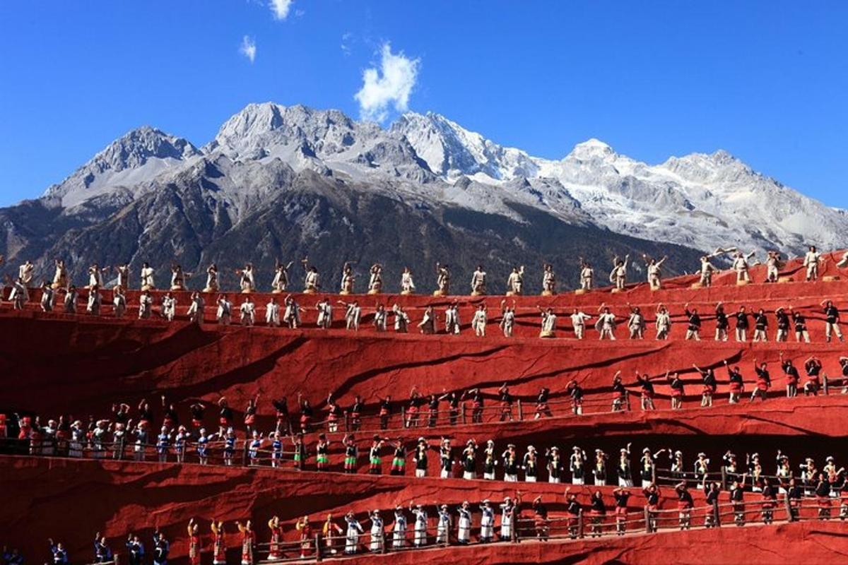 a group of people on a stage with mountains in the background
