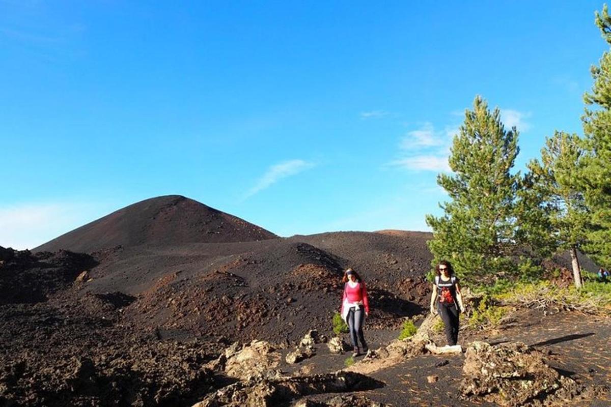 due persone su un sentiero sterrato con una montagna sullo sfondo