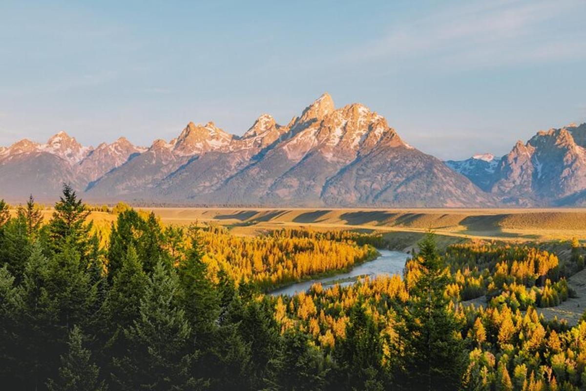 una vista di una catena montuosa con un fiume e alberi