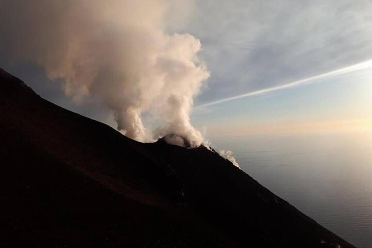 a smoke stack on top of a hill with the sky