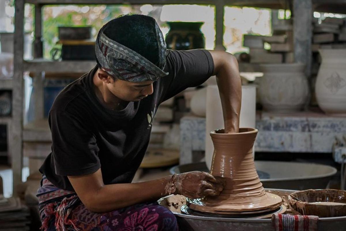 a man making a vase on a pottery wheel