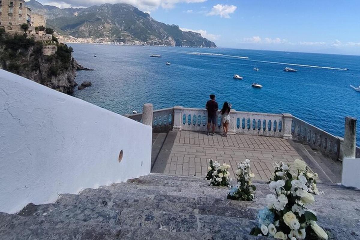 un uomo e una donna in piedi su una scala che guardano l'oceano