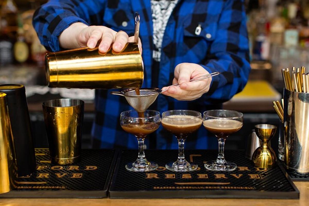 ein Barkeeper gießt einen Drink in zwei Gläser