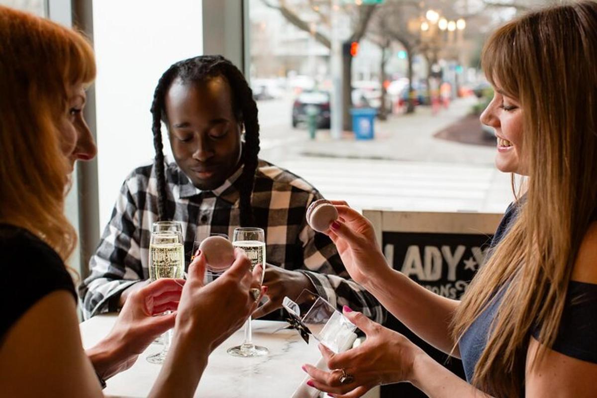 drei Personen sitzen an einem Tisch und trinken Weingläser
