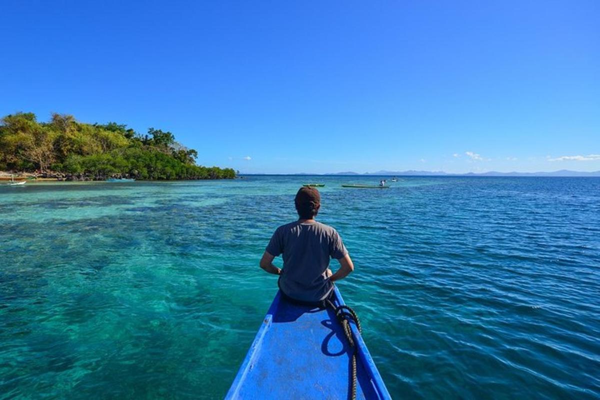 Un hombre está remando en un kayak azul en el agua.