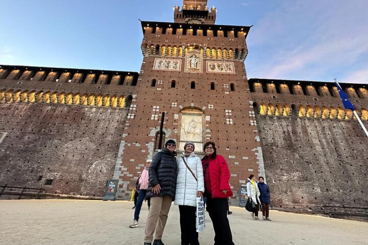 un gruppo di persone in piedi davanti a una torre dell'orologio