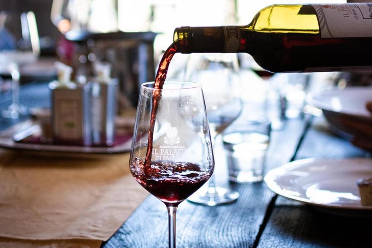 una persona sta versando del vino in un bicchiere da vino