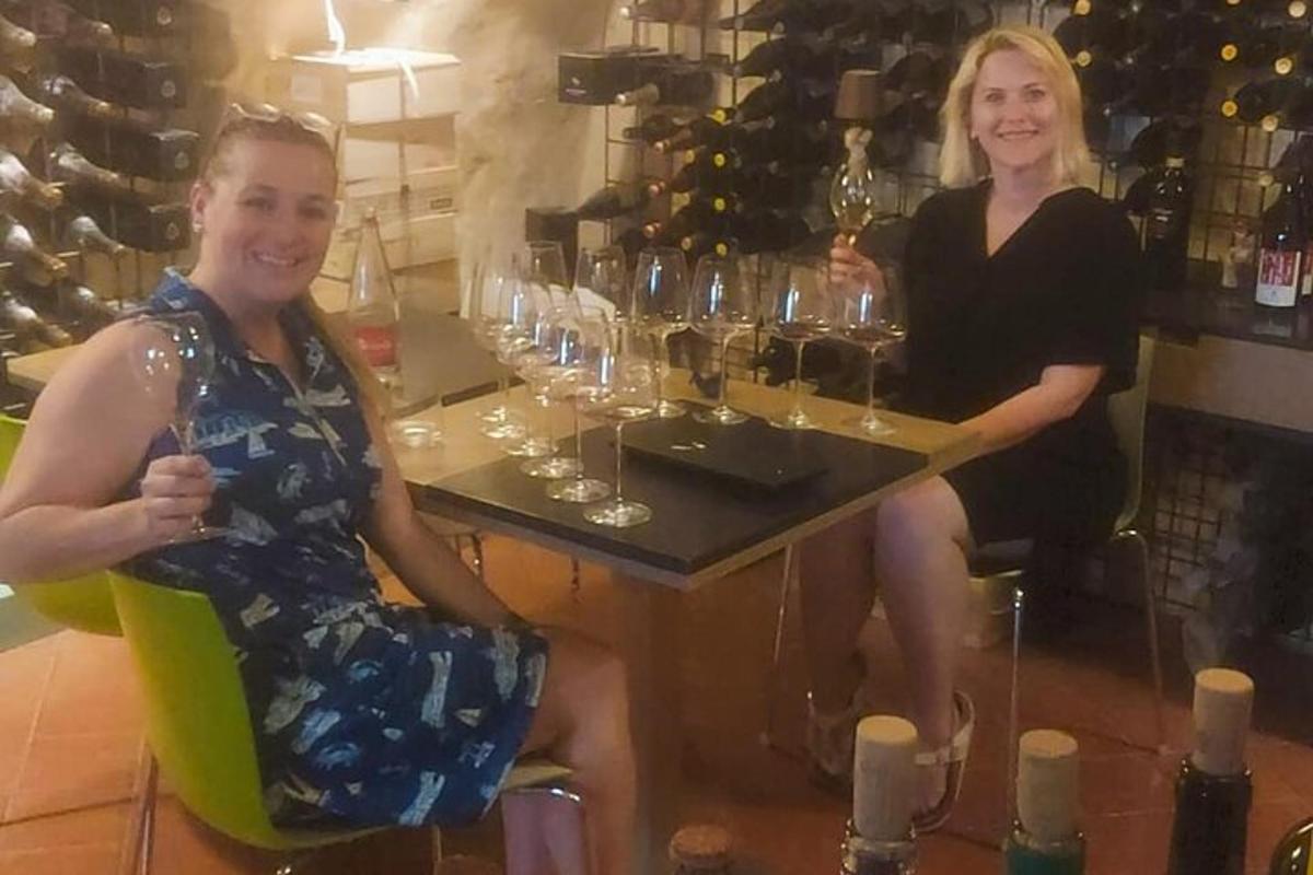 two women sitting at a bar with wine glasses