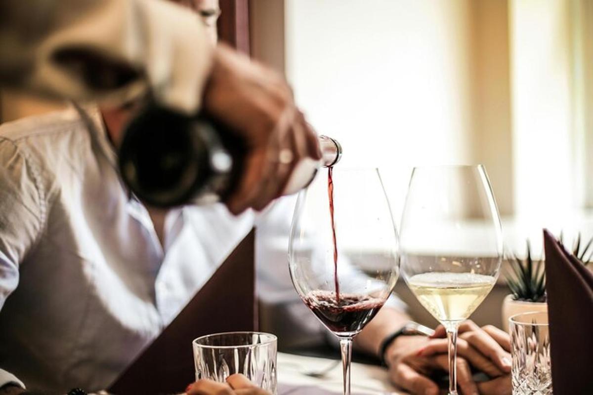 a man pouring a glass of red and white wine