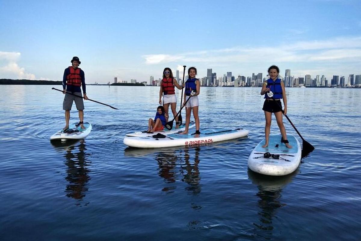 skupina ľudí stojacich na paddleboardoch vo vode