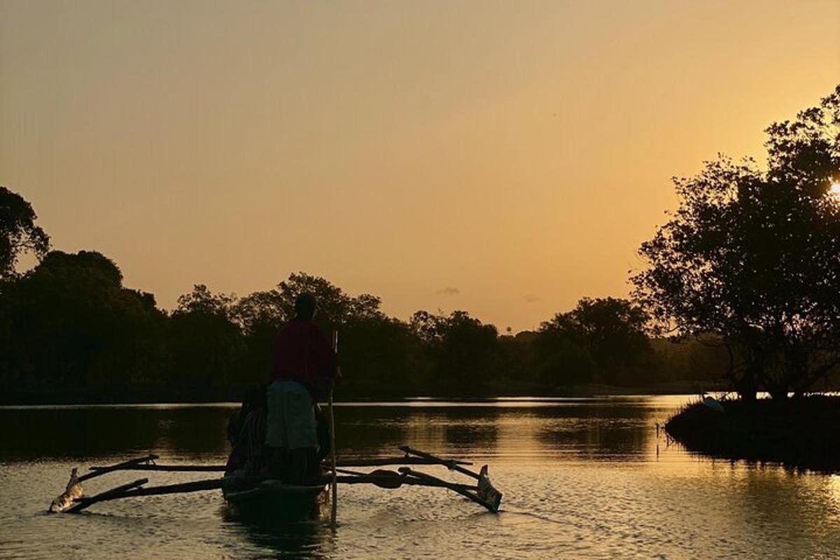 a man in a boat on a river at sunset