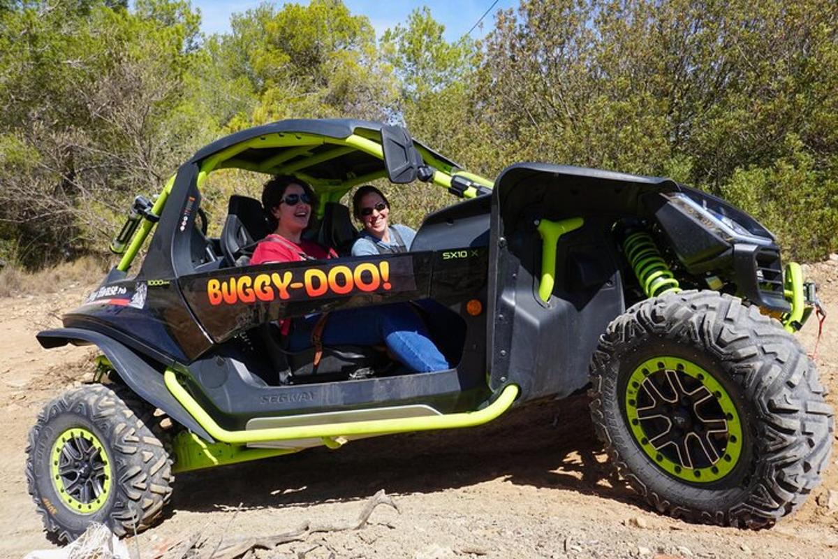 dva lidé sedící v hračkovém náklaďáku na prašné cestě