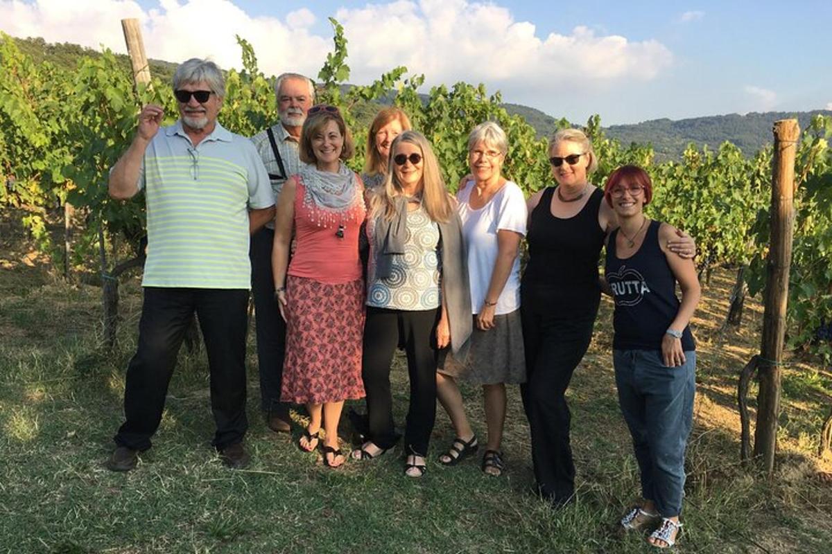 a group of people posing for a picture in a vineyard