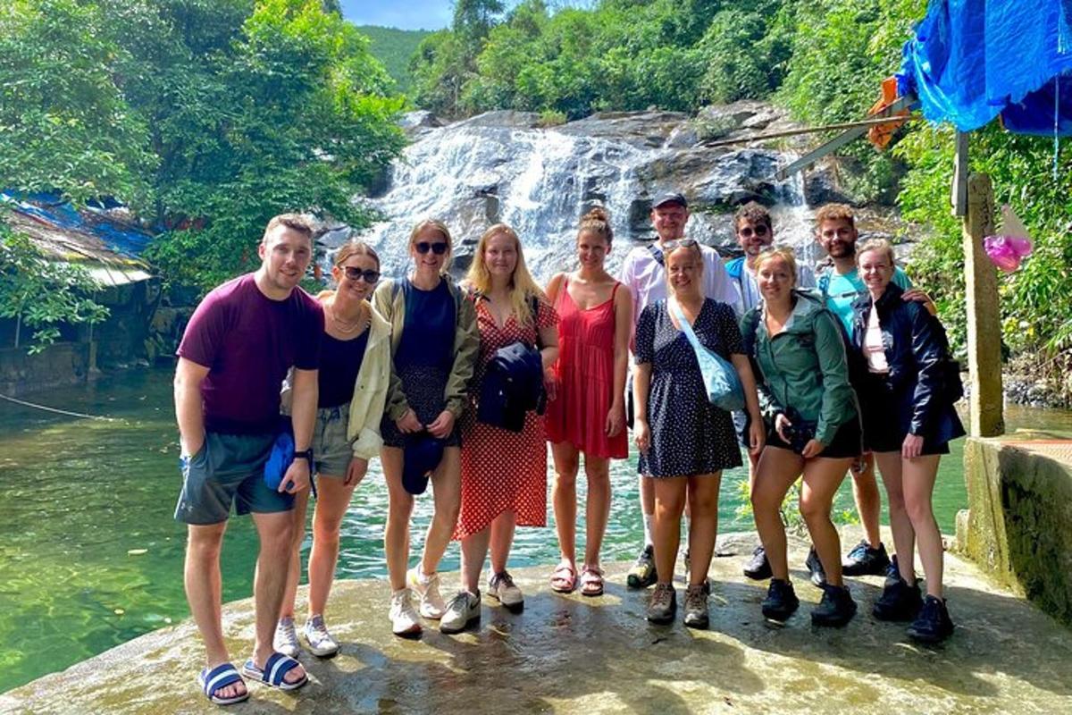 a group of people standing in front of a waterfall