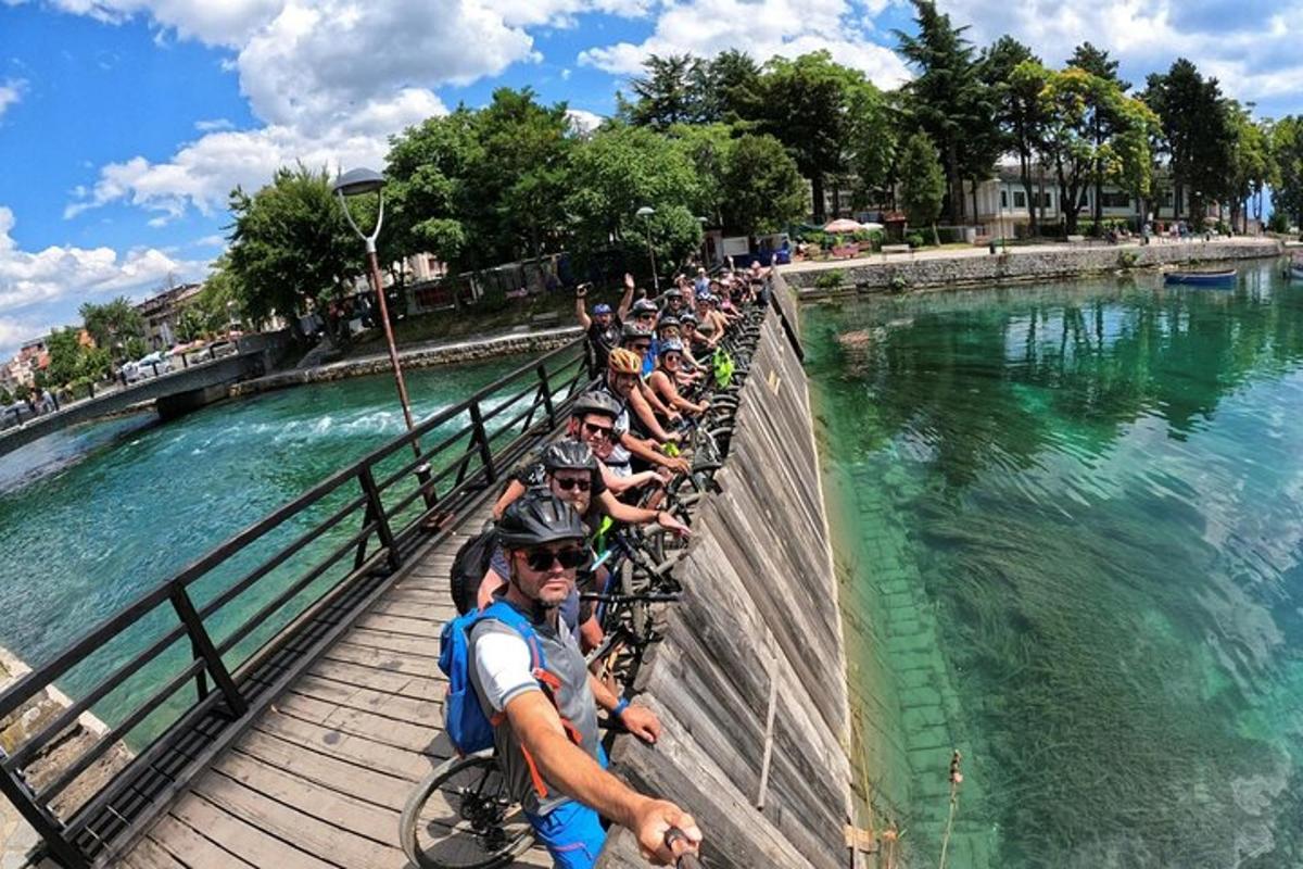a group of people riding bikes on a bridge over water