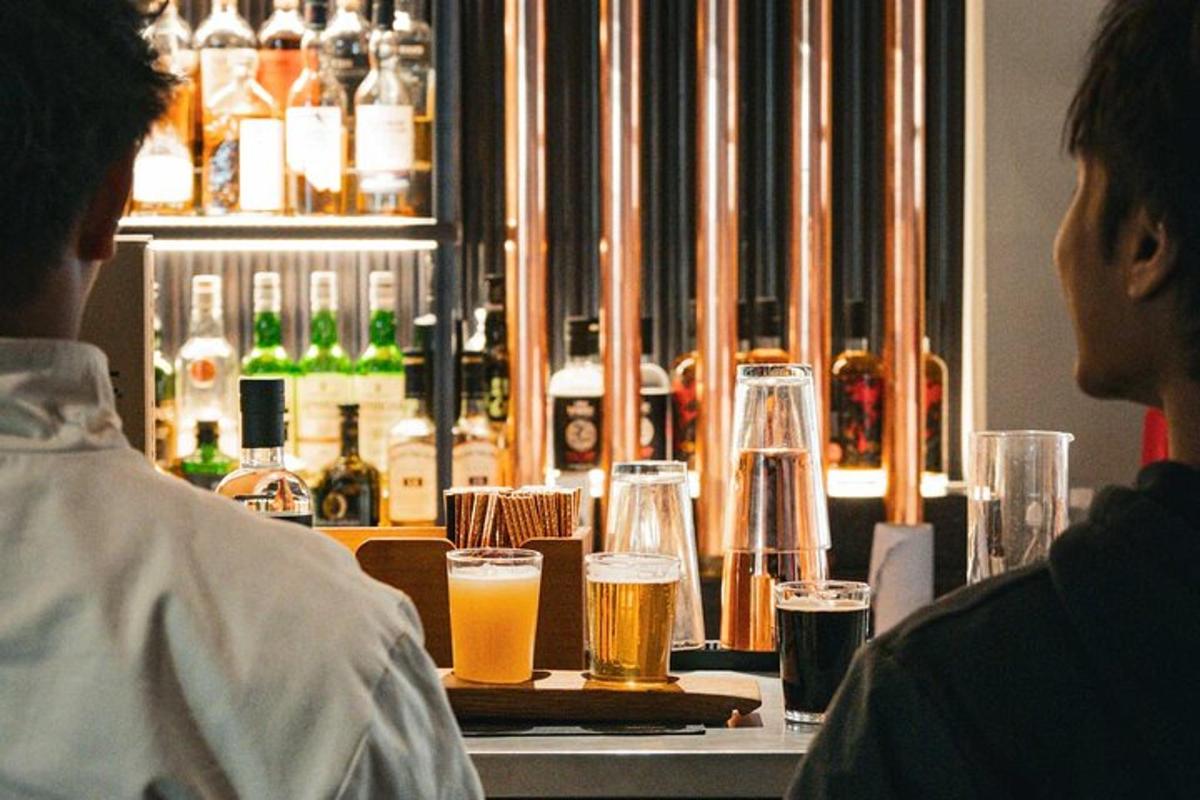 Δύο άτομα κάθονται σε ένα μπαρ με ποτήρια μπύρας