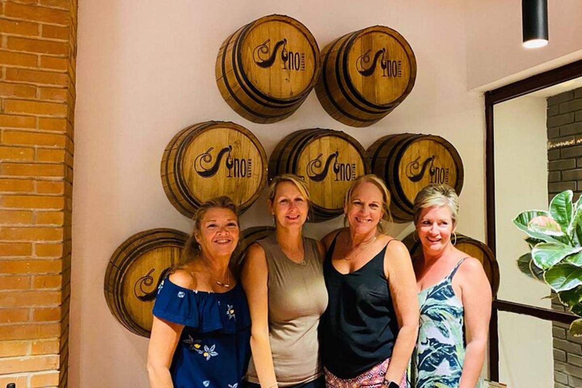 a group of women standing in front of wine barrels
