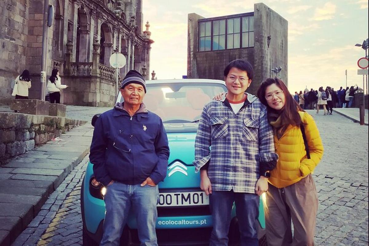 Un grupo de tres personas de pie delante de un coche.