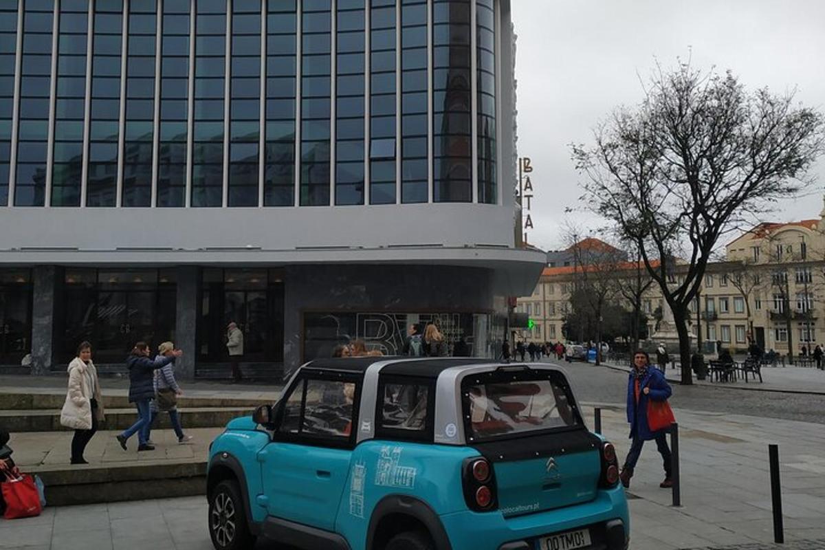 Un coche pequeño aparcado delante de un edificio
