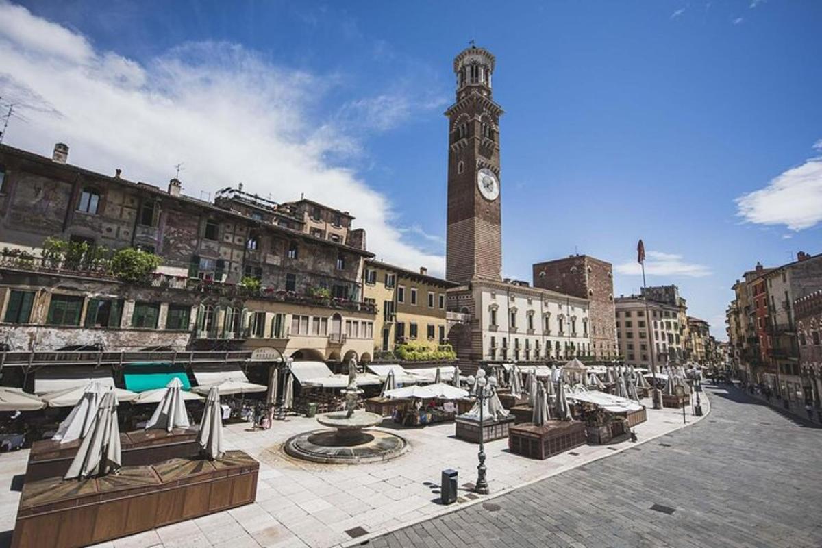 una piazza cittadina con una torre dell'orologio con un orologio
