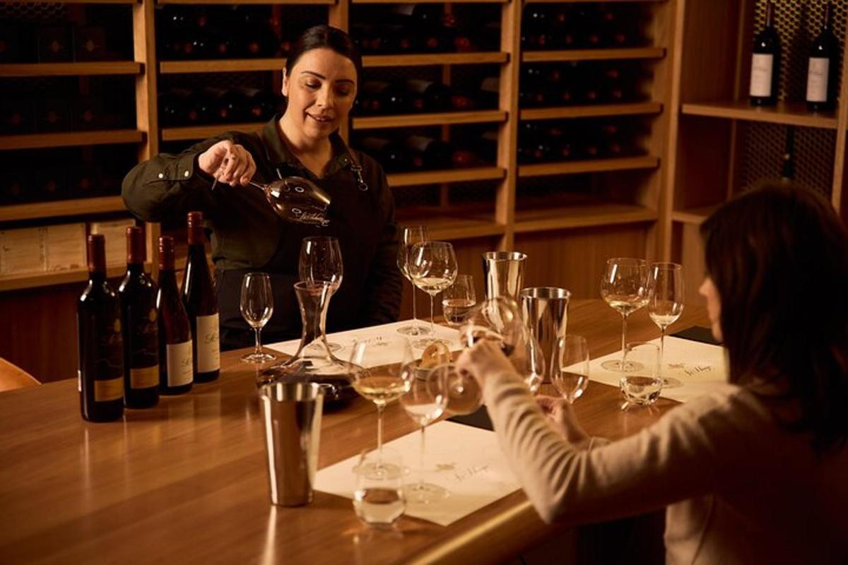 două persoane așezate la o masă cu pahare de vin