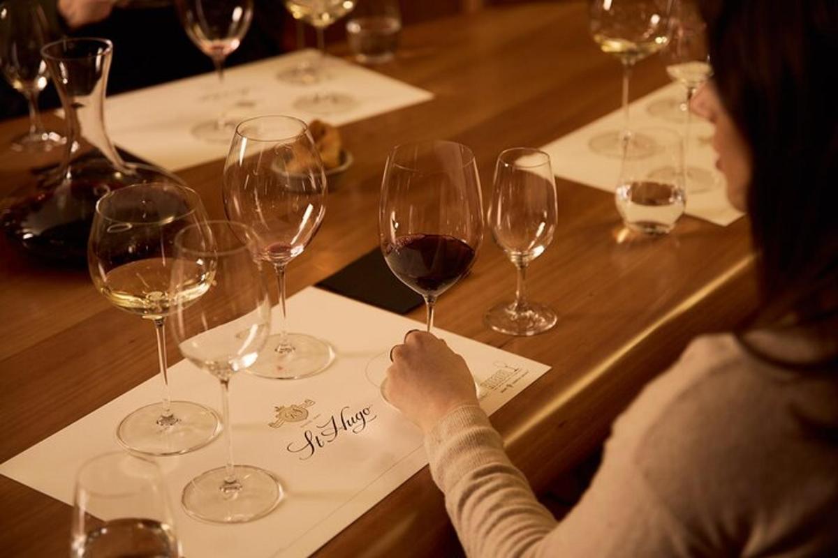 uma mulher sentada à mesa com taças de vinho