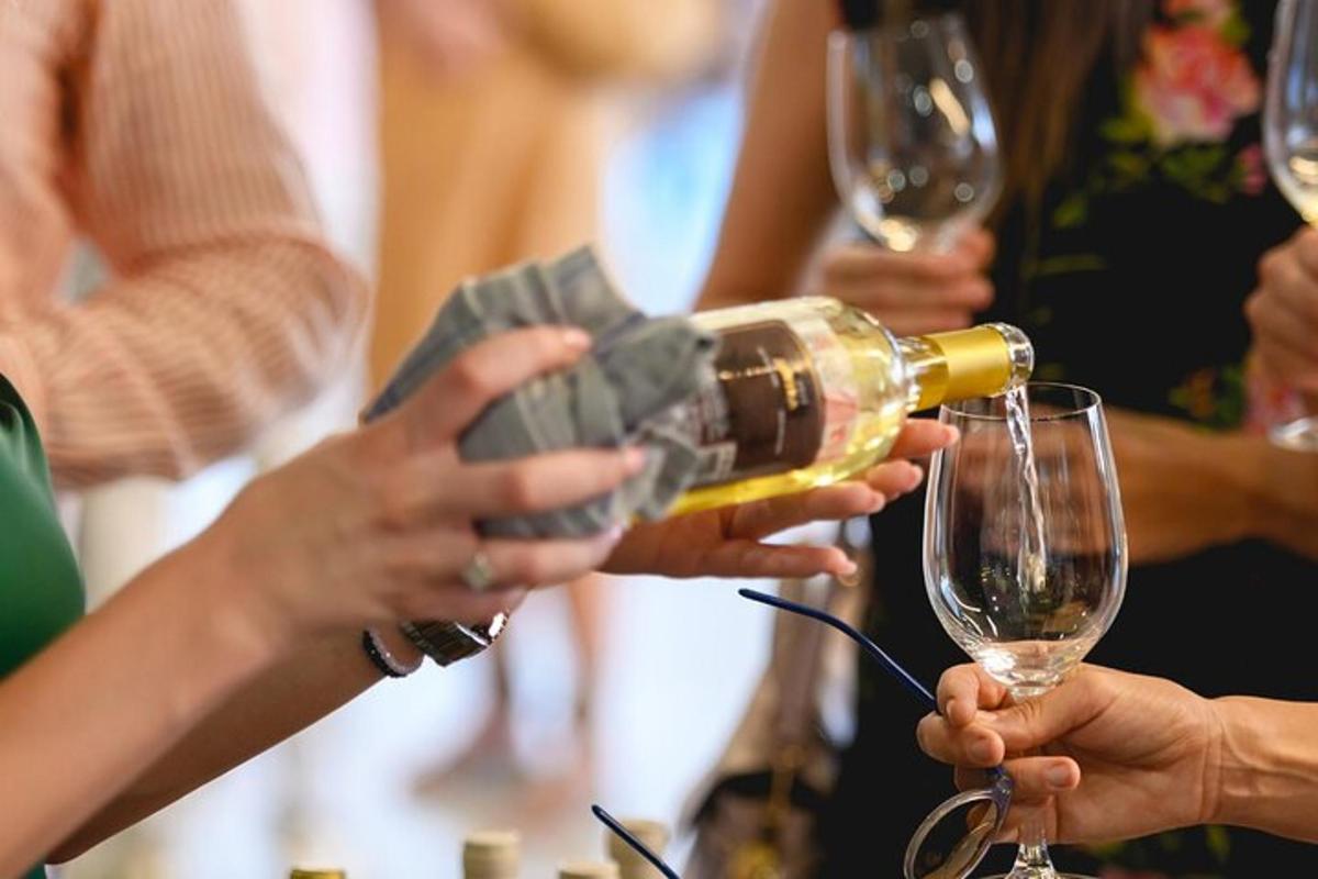 un gruppo di persone che versano il vino nei bicchieri