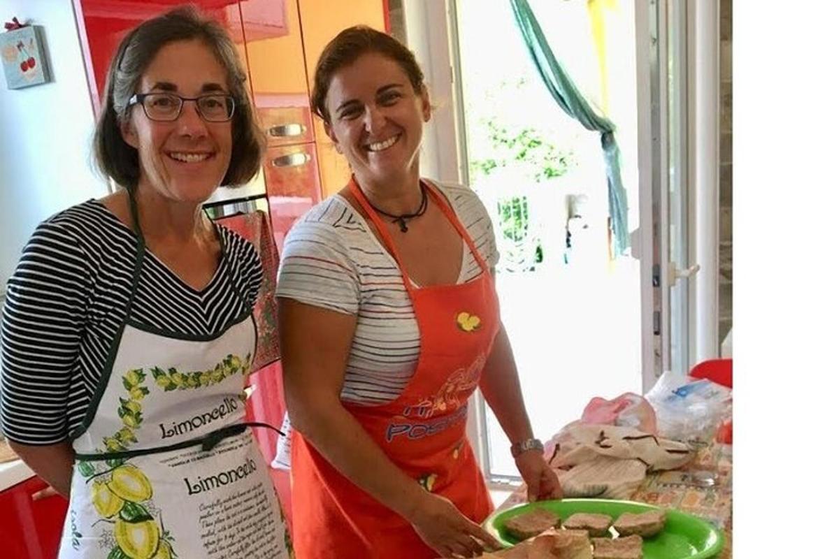 due donne in piedi in cucina con un piatto di cibo