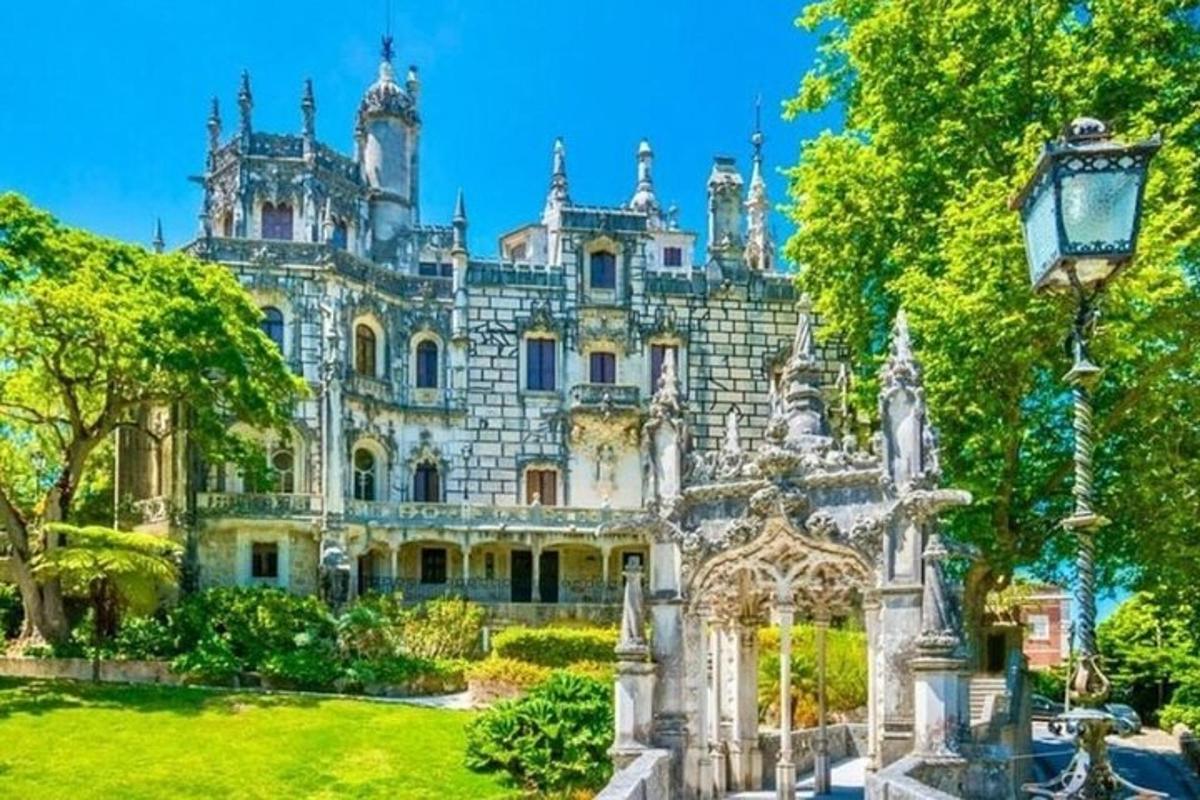 Una antigua mansión con un jardín delante de ella.