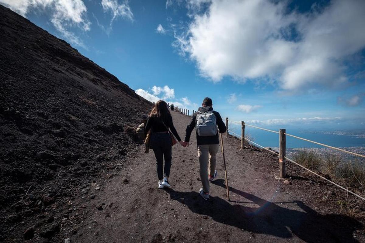 dues persones caminant per un camí de terra agafades de la mà