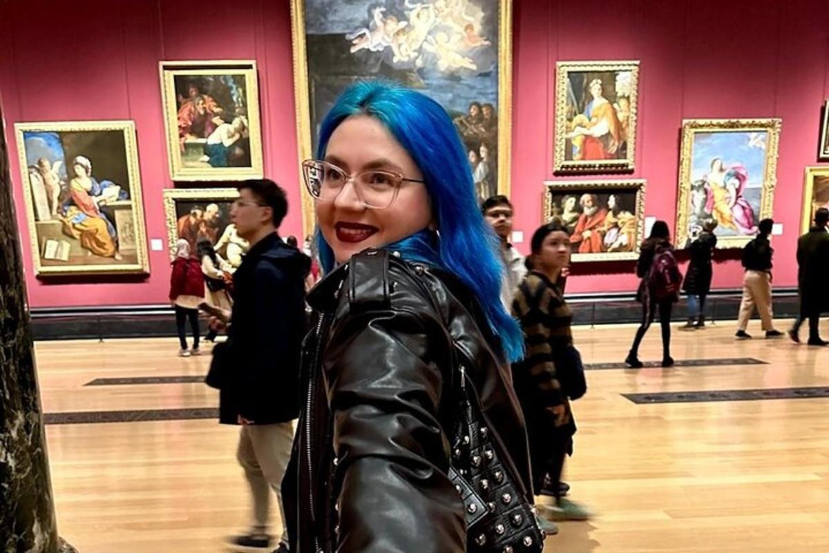 a woman with blue hair standing in a museum