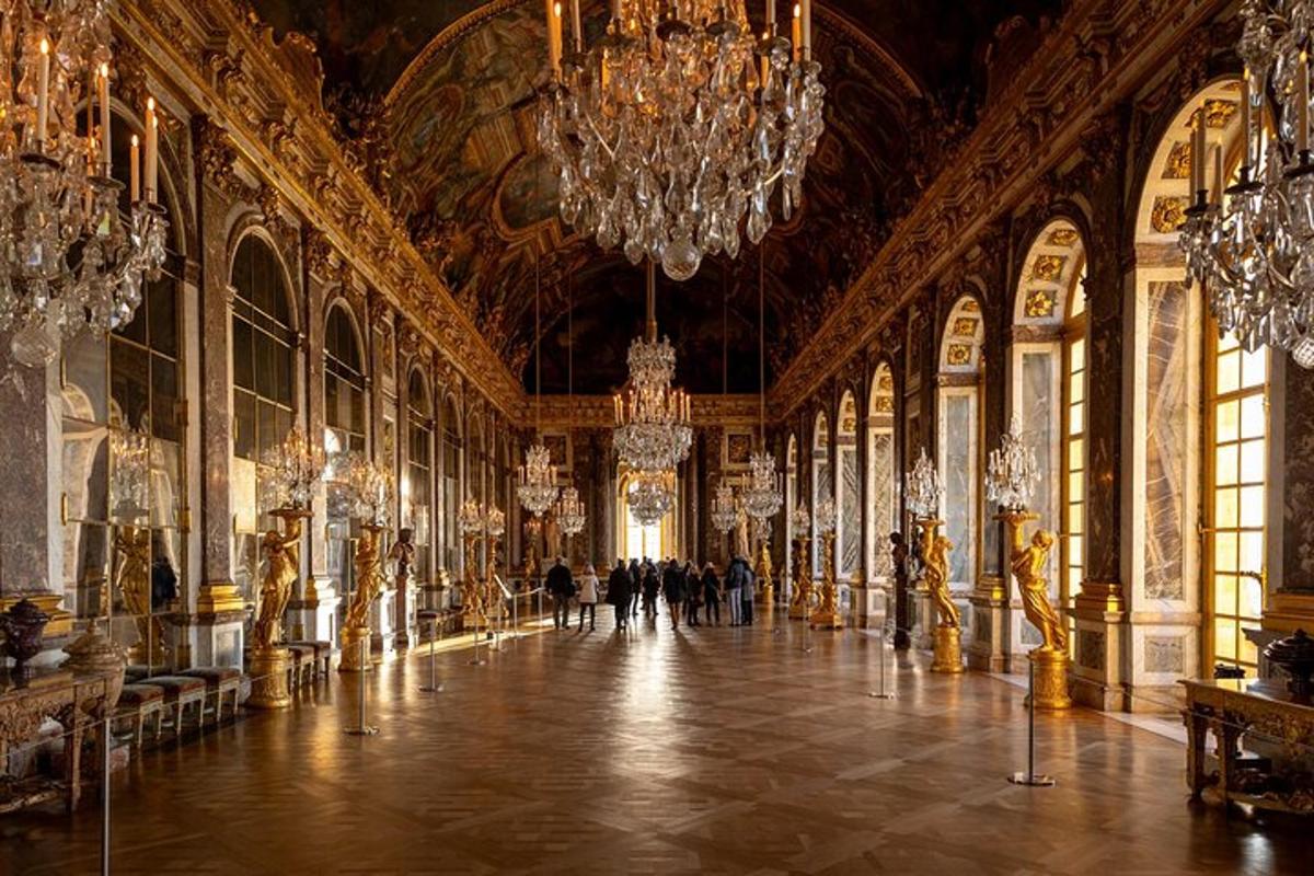a large room with chandeliers and people walking through it