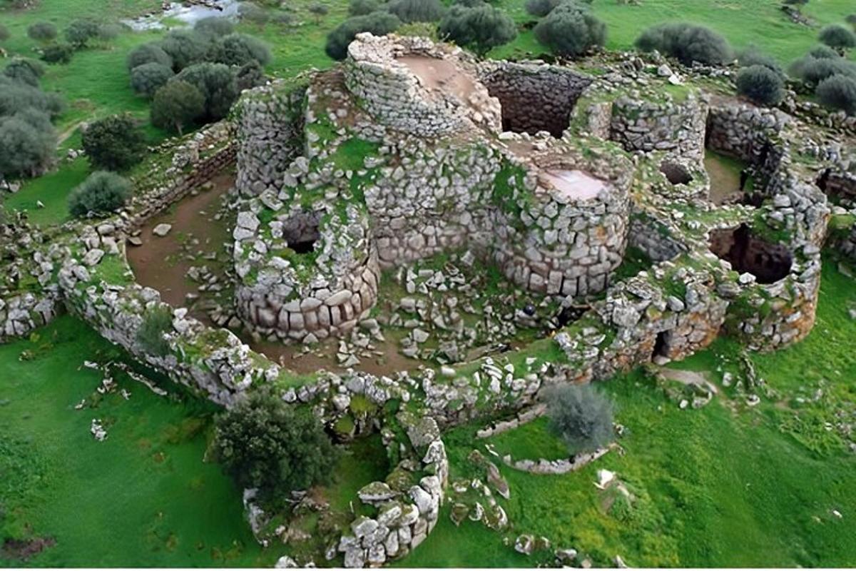 an aerial view of a stone building in a field